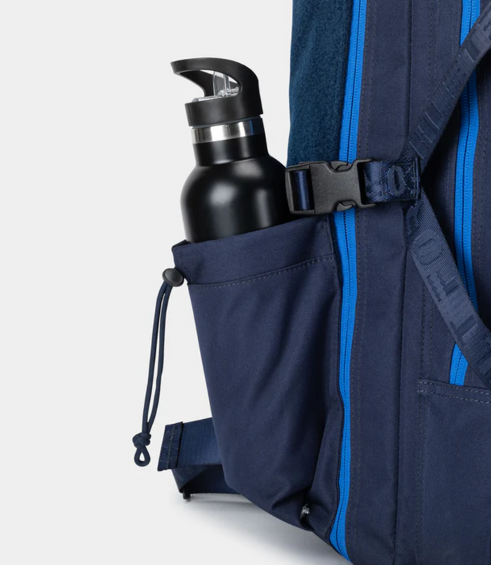 Water bottle in side pocket of navy Built for Athletes 45L backpack with bright blue zipper accents