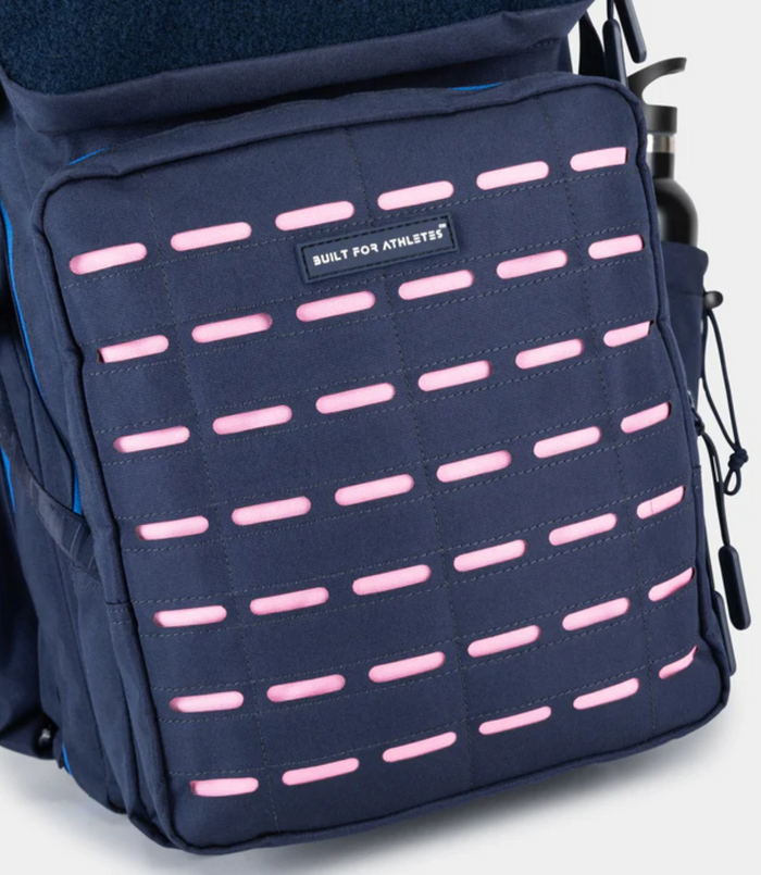 Close up of navy blue Built for Athletes 45L backpack front panel with pink dash accents and a Built for Athletes patch