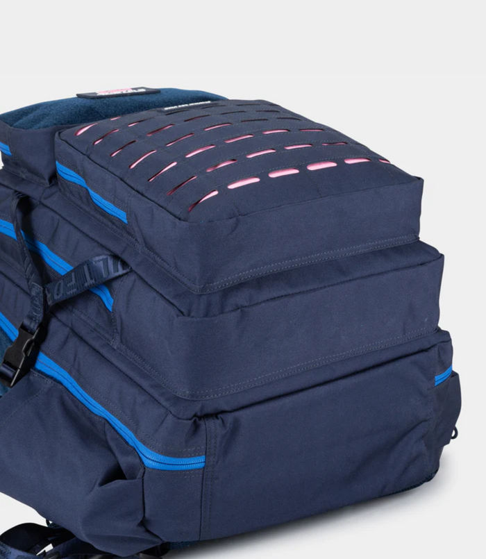 Top portion of navy backpack with vivid blue zipper and handle, highlighting the compact design