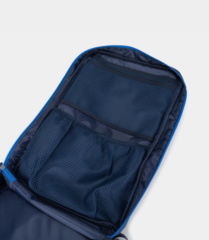 Open main compartment showing interior mesh pocket and blue zipper trim inside the navy backpack.