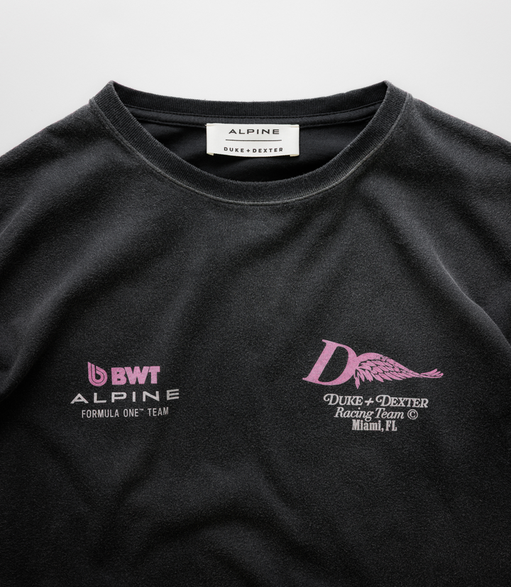 Close up of the white neck label reading ALPINE DUKE+DEXTER on a black Washed T-shirt