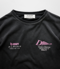 Close up of the white neck label reading ALPINE DUKE+DEXTER on a black Washed T-shirt