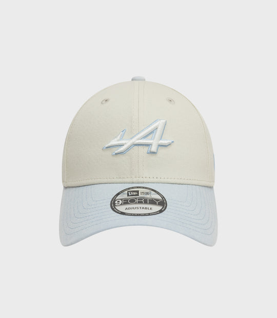 Beige creme crown 9Forty cap with a light blue brim viewed from the front with sticker on the brim