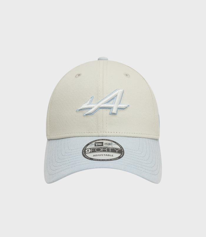 Beige creme crown 9Forty cap with a light blue brim viewed from the front with sticker on the brim