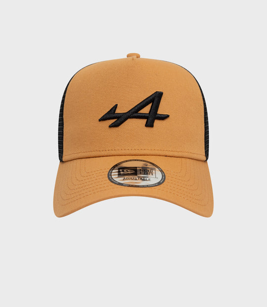 Beige New Era Alpine Seasonal E-Fame trucker cap with black embroidered front logo and visible sticker on the brim.