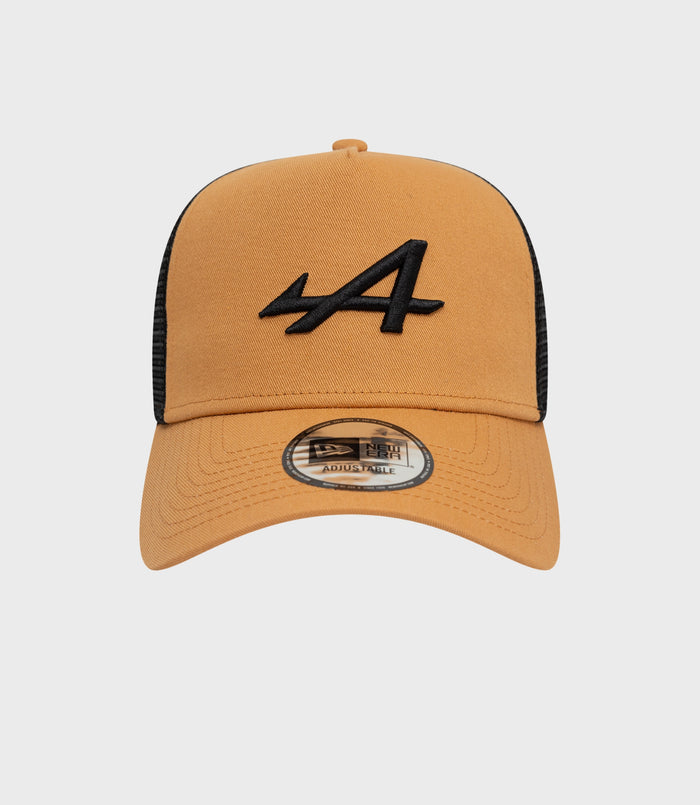 Beige New Era Alpine Seasonal E-Fame trucker cap with black embroidered front logo and visible sticker on the brim.