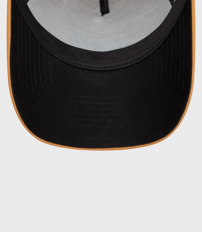 Beige cap brim close-up showing stitching and black underside with adjustable strap visible