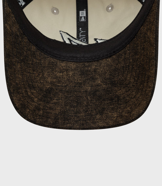 Close-up of an acid wash brown New Era 9Twenty cap with a black edge and beige interior