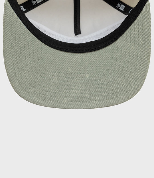 Close-up of olive green Alpine acid wash golfer cap front with black trim around the brim