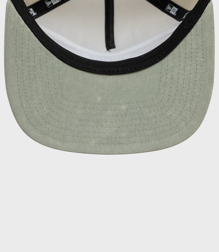 Close-up of olive green Alpine acid wash golfer cap front with black trim around the brim