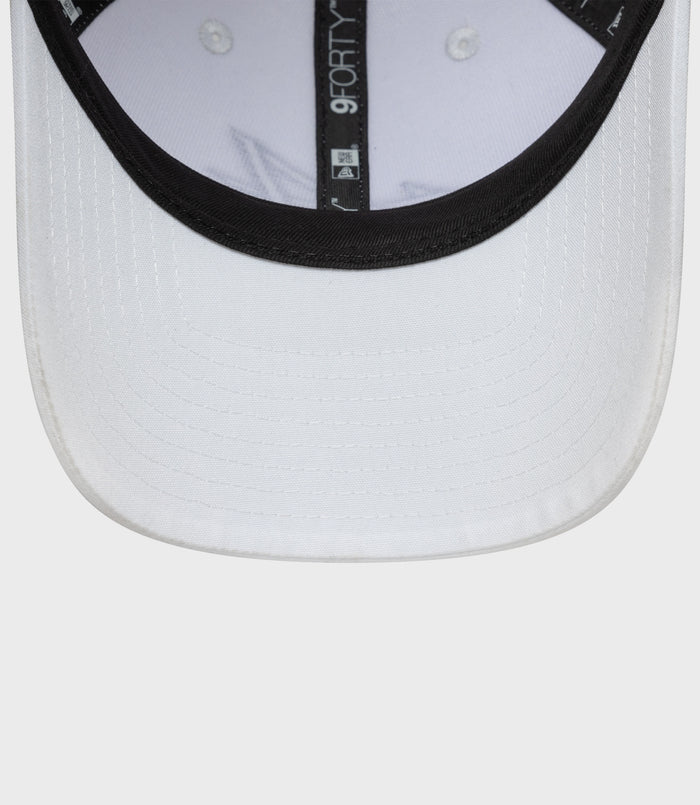 Close-up of a white New Era 9FORTY cap brim with black edge and vertical 9FORTY label inside