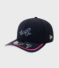 Navy New Era 9Seventy Stretch Snap Cap with a large white front logo, pink trim on the brim, and a New Era emblem on the side.