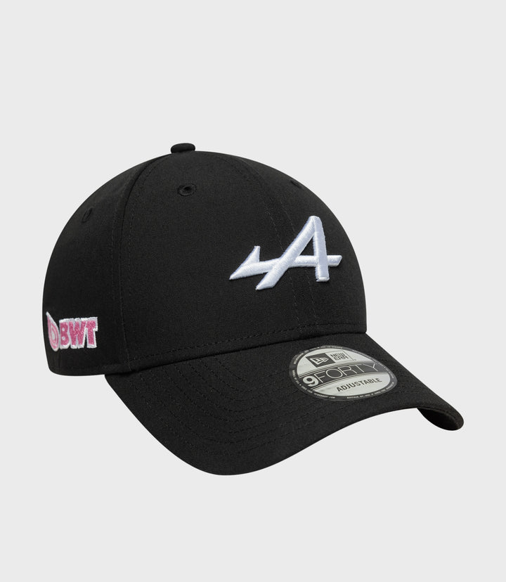 Black cap with pink embroidered side patch and New Era 9FORTY adjustable sticker visible on the brim.