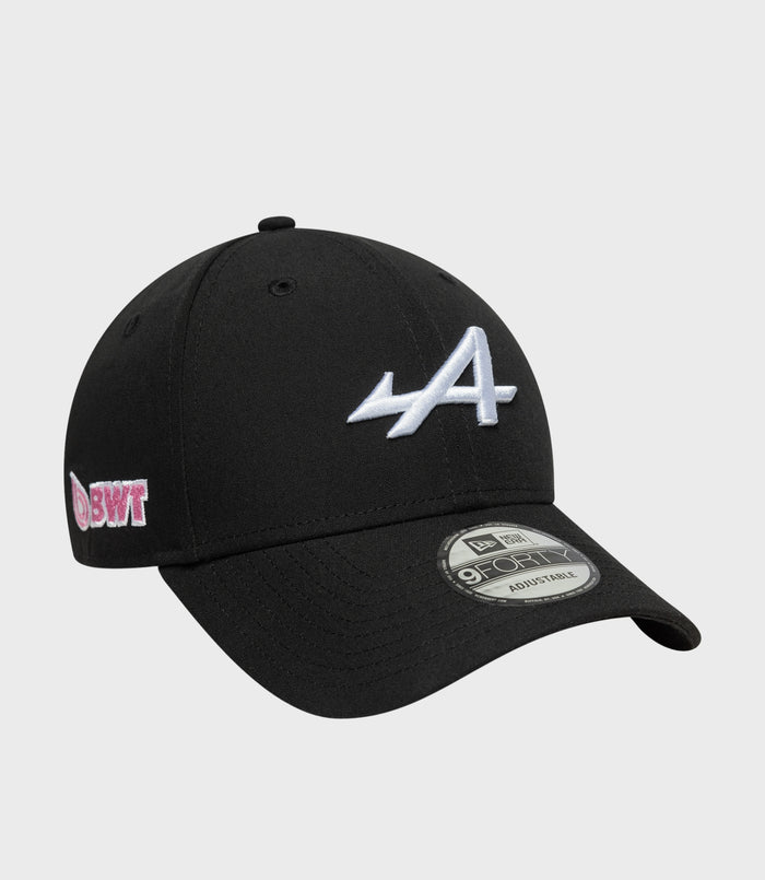 Black cap with pink embroidered side patch and New Era 9FORTY adjustable sticker visible on the brim.