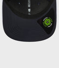 Navy cap brim close up showing neon green New Era sticker and rear strap