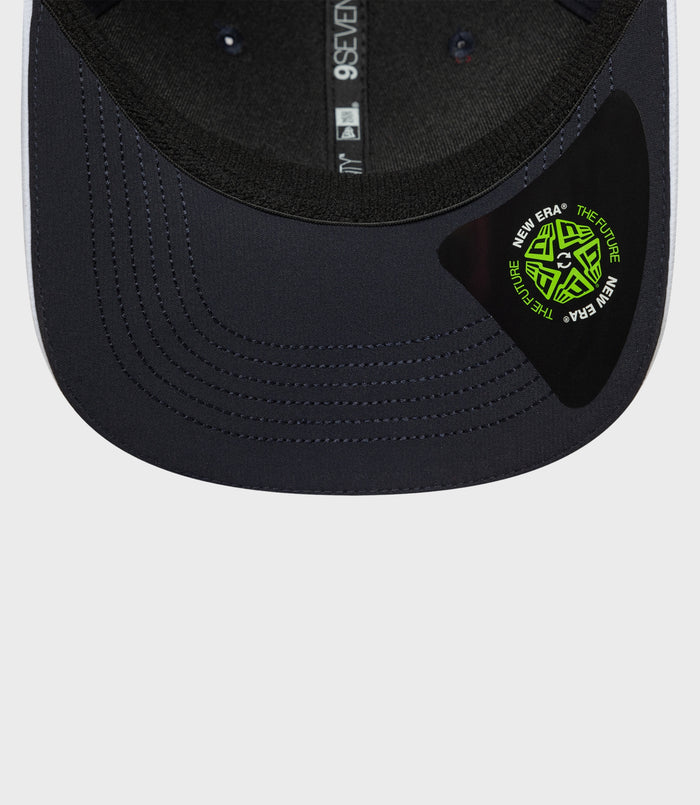 Navy cap brim close up showing neon green New Era sticker and rear strap