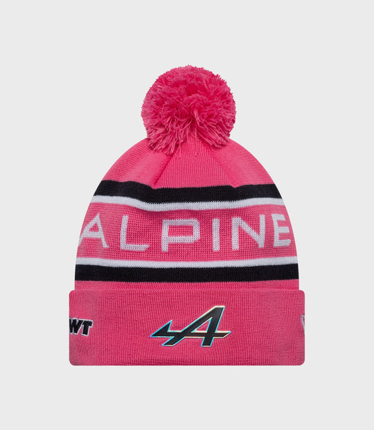 Pink knit beanie with a fluffy pom and Alpine branding on the cuff