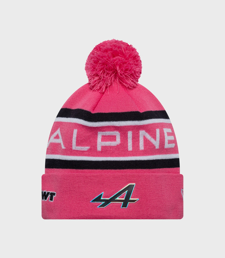 Pink knit beanie with a fluffy pom and Alpine branding on the cuff