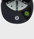 Inside view of navy cap showing gray lining and 59FIFTY branding on the inner tape with a circular New Era sticker on the brim.