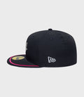 Side view of navy New Era Alpine 59Fifty cap with white logo on the side and pink brim trim