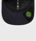 Interior view of navy 9Seventy cap showing vertical strap branding and a neon logo patch on the brim