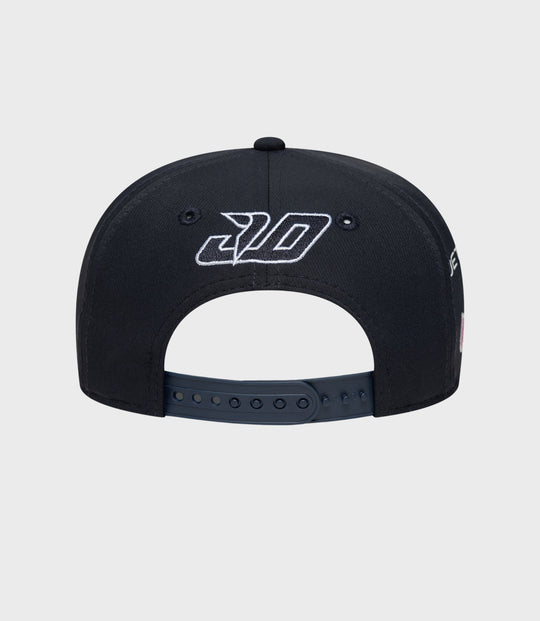 Rear view of navy cap with white embroidered logo on crown panels