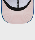 Interior close up of pastel pink cap with black trim and blue top button