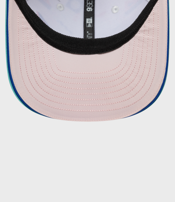 Interior close up of pastel pink cap with black trim and blue top button