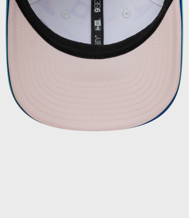Close up of pink crown with black trim and teal brim on New Era Alpine Miami 9Seventy Stretch Snap Cap.