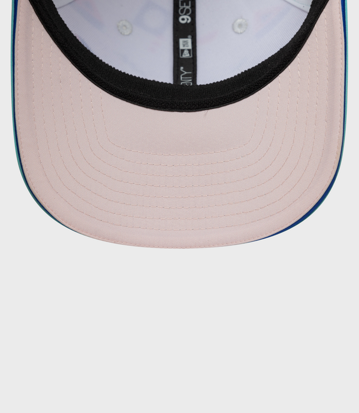 Close up of pink crown with black trim and teal brim on New Era Alpine Miami 9Seventy Stretch Snap Cap.
