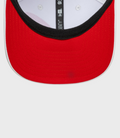 Close up of front of white New Era Alpine Japan 9Seventy cap with red brim and black inner band