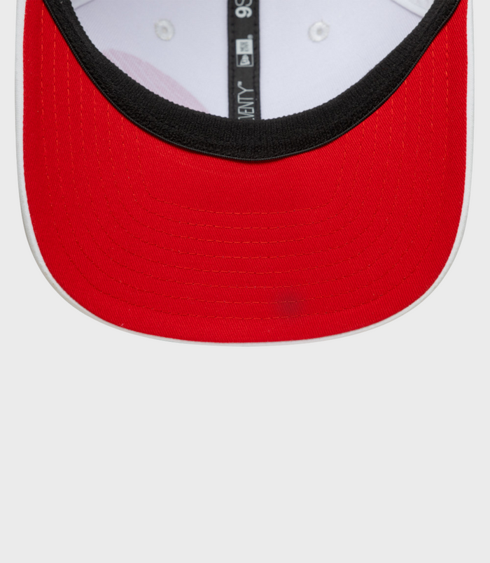 Close up of front of white New Era Alpine Japan 9Seventy cap with red brim and black inner band
