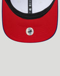 Close up of a New Era 9Seventy race cap showing a red brim with a navy edge and black inner band.