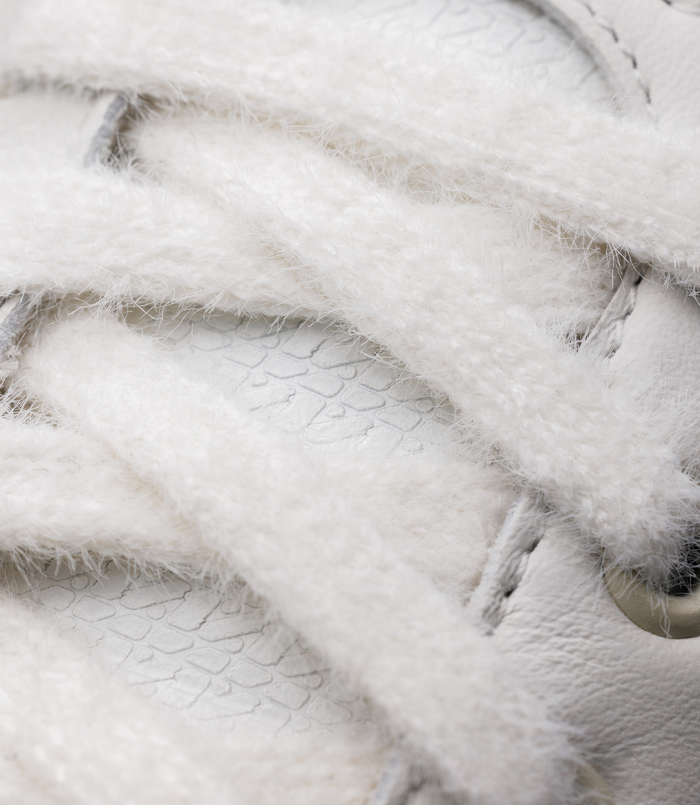 Close-up of plush white fur lining with a glimpse of the sneaker sole