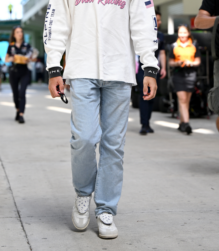 Lower body of a person wearing light blue jeans and white Duke and Dexter sneakers with a starry patterned strap