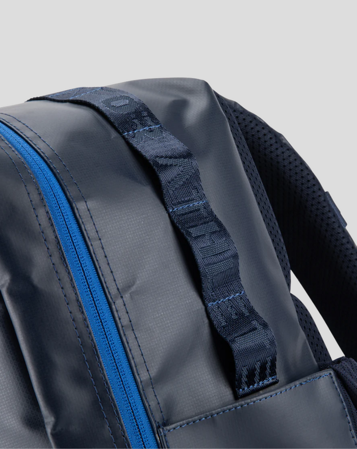 Close up of the TYRO 20L backpack strap with jacquard webbing and a blue zipper
