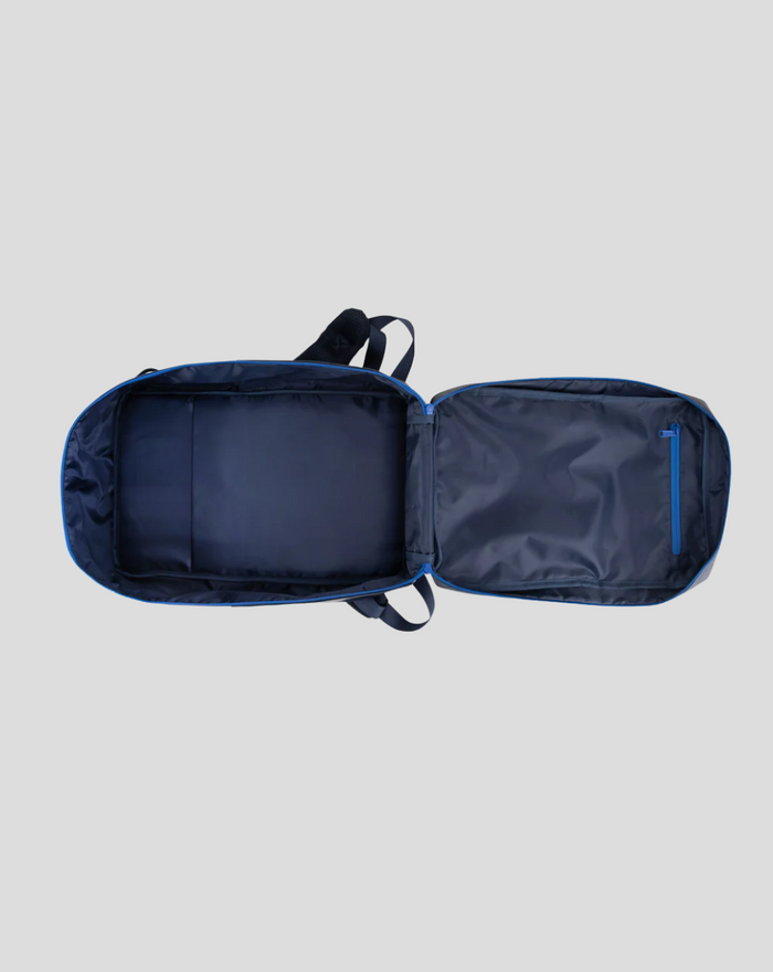 TYRO 20L backpack opened flat showing interior compartments and a blue zip pocket on the right panel
