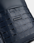 Close up of the TYRO 20L backpack navy panel with a grid of stitched slots and a Built for Athletes label