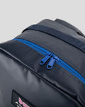 Close up of blue zipper on navy TYRO 20L backpack with strap detail.