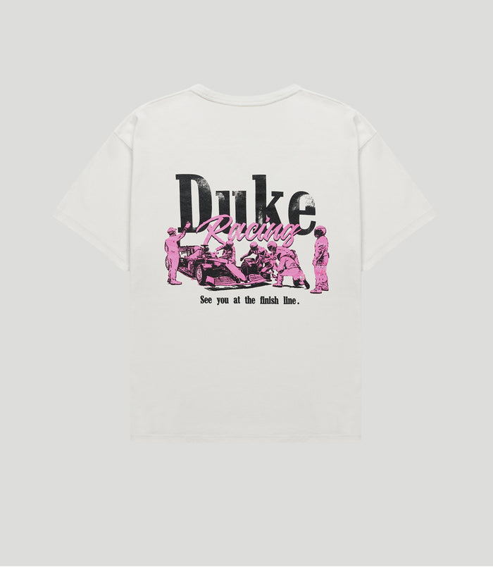 Back view of white vintage style T shirt with large black Duke text and pink Racing script graphic depicting a racing scene