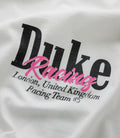 Close up of white fabric highlighting the black Duke letters with pink Racing script overlay