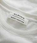 Close up of white T shirt showing a stitched Alpine label with Duke Dexter branding