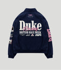 Back view of navy racing jacket with large white Duke lettering and pink Racing script and BWT Alpine logo near the neck.