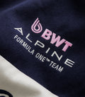Close-up of navy jacket fabric showing embroidered Duke branding with pink letters and a winged emblem.