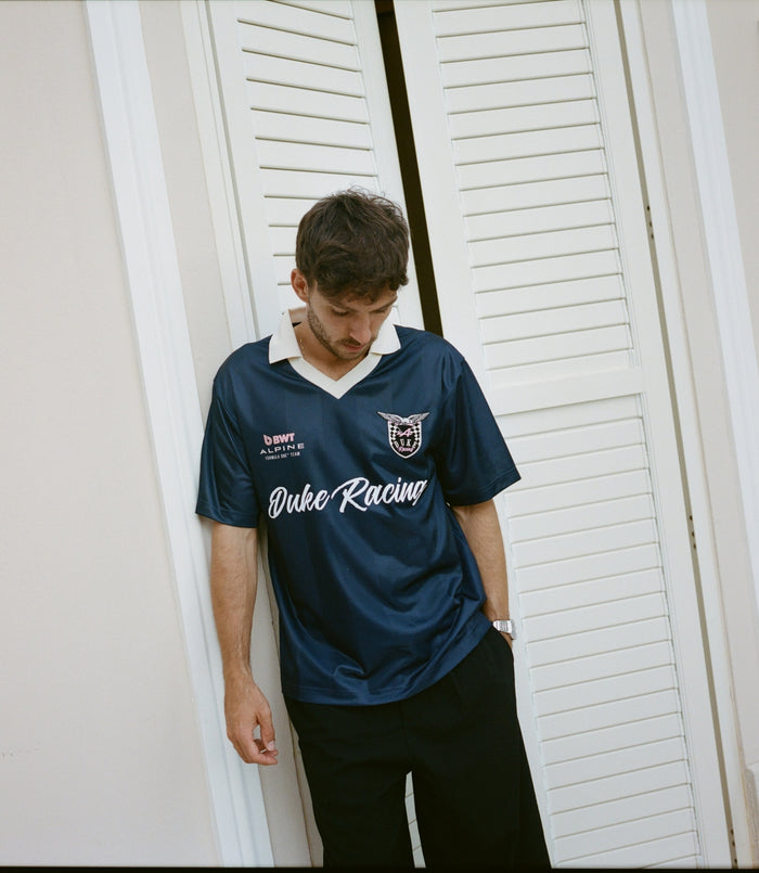 Front view of a man wearing a navy blue sports jersey with a white V collar
