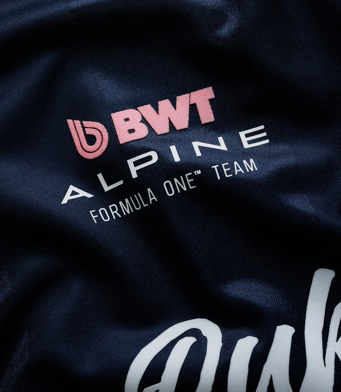 Close up of navy blue Duke & Dexter sports jersey fabric with pink BWT logo and Alpine Formula One Team branding