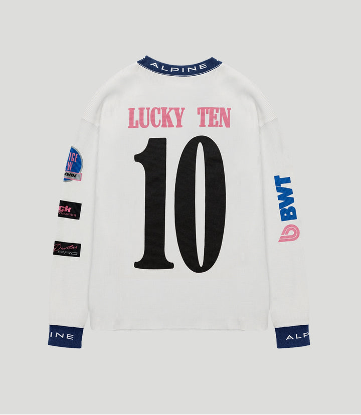 Back view of a white BWT Alpine jersey with pink LUCKY TEN above a large black 10 and a blue Alpine collar.