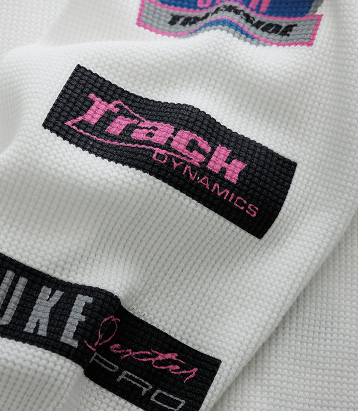 Black tag with pink Duke & Dexter branding on white textured fabric