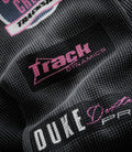 Close up of black washed waffle jersey fabric featuring a pink Duke & Dexter patch on a white label
