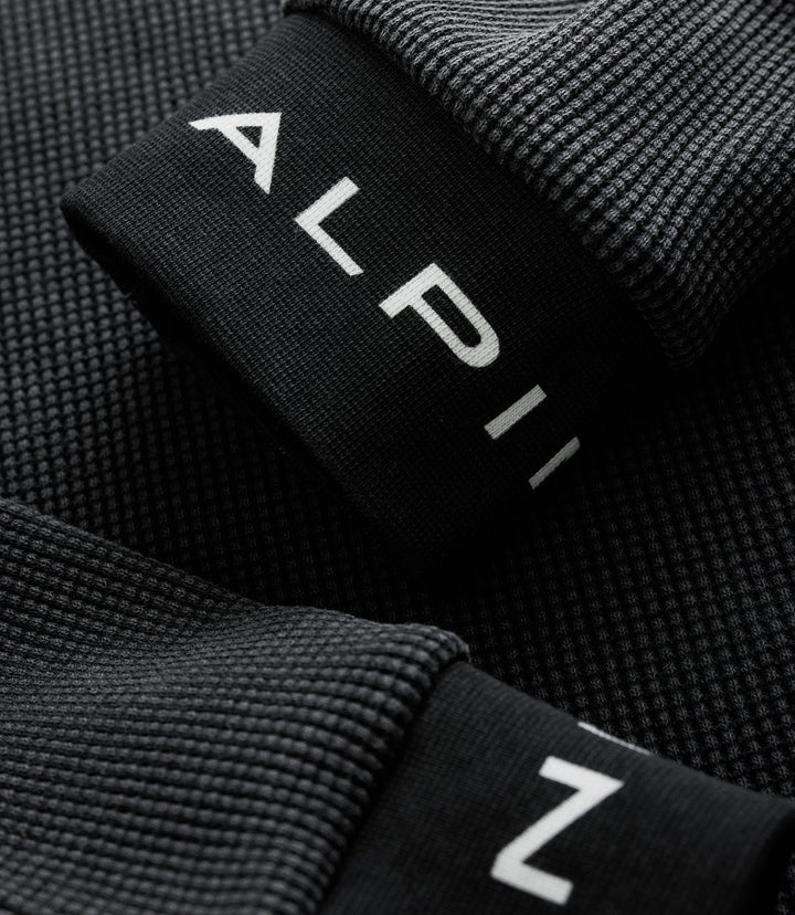 Close up of black jersey edge showing white Alpine letters printed on the fabric fold